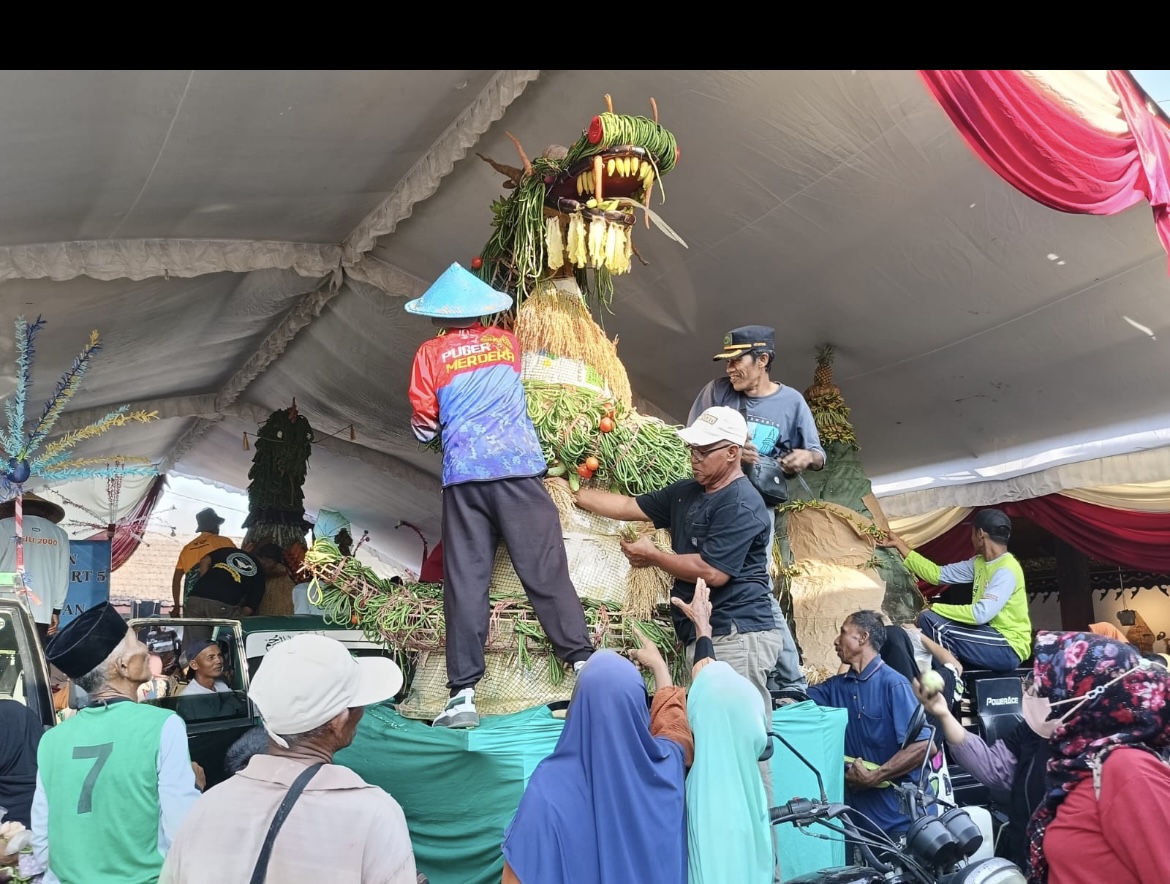 RAMAI: Sejumlah warga saat berebut gunungan hasil bumi dalam festival ketan di Desa Darungan, Kecamatan Yosowilangun. (ATIEQSON MAR IQBAL/RAME)
