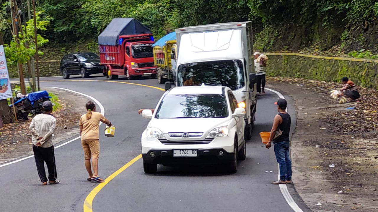 BAWA BERKAH: Ketika jalur gumitir diberlakukan dengan sistem buka tutup karena ada kecelakaan membawa berkah tersendiri bagi relawan awe awe. (JUMAI/RJ)