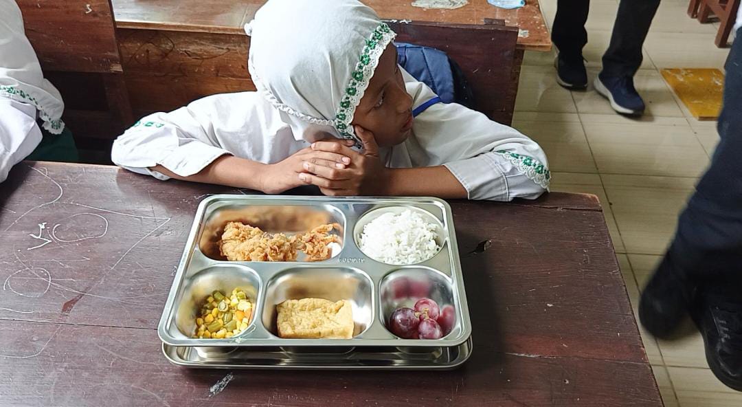 Salah satu siswa di sebuah sekolah dasar swasta akan menyantap menu MBG (Foto: Maulana/Radar Jember)