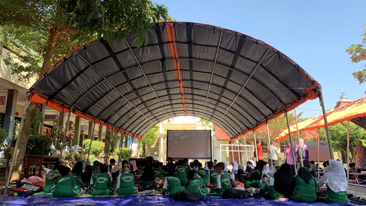 TERBATAS: Kondisi para siswa dan guru SDN Kota Kulon 2 Bondowoso ketika melaksanakan kegiatan belajar mengajar di bawah tenda darurat BPBD Bondowoso.(ILHAM WAHYUDI/RADAR IJEN)