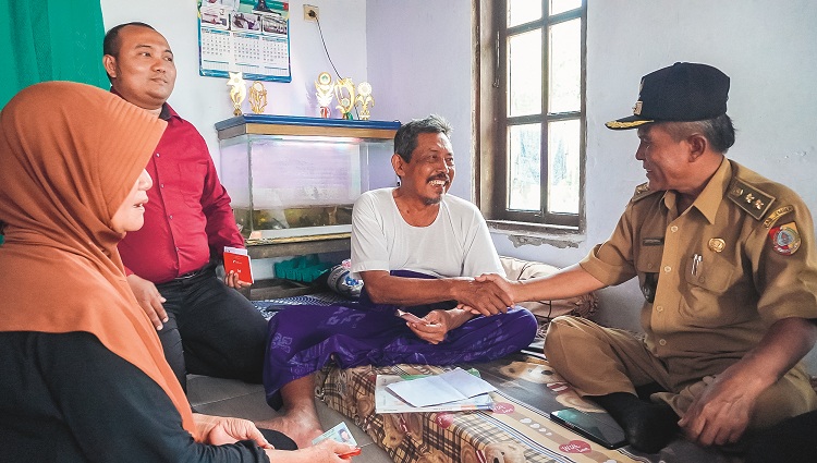 HANGAT: Petugas dari perbankan dan pemerintah desa mendatangi kediaman Kiai Sanusi, tokoh agama penerima program insentif guru ngaji, di Desa Pondokjoyo, Kecamatan Semboro, Jember, Senin (6/10).