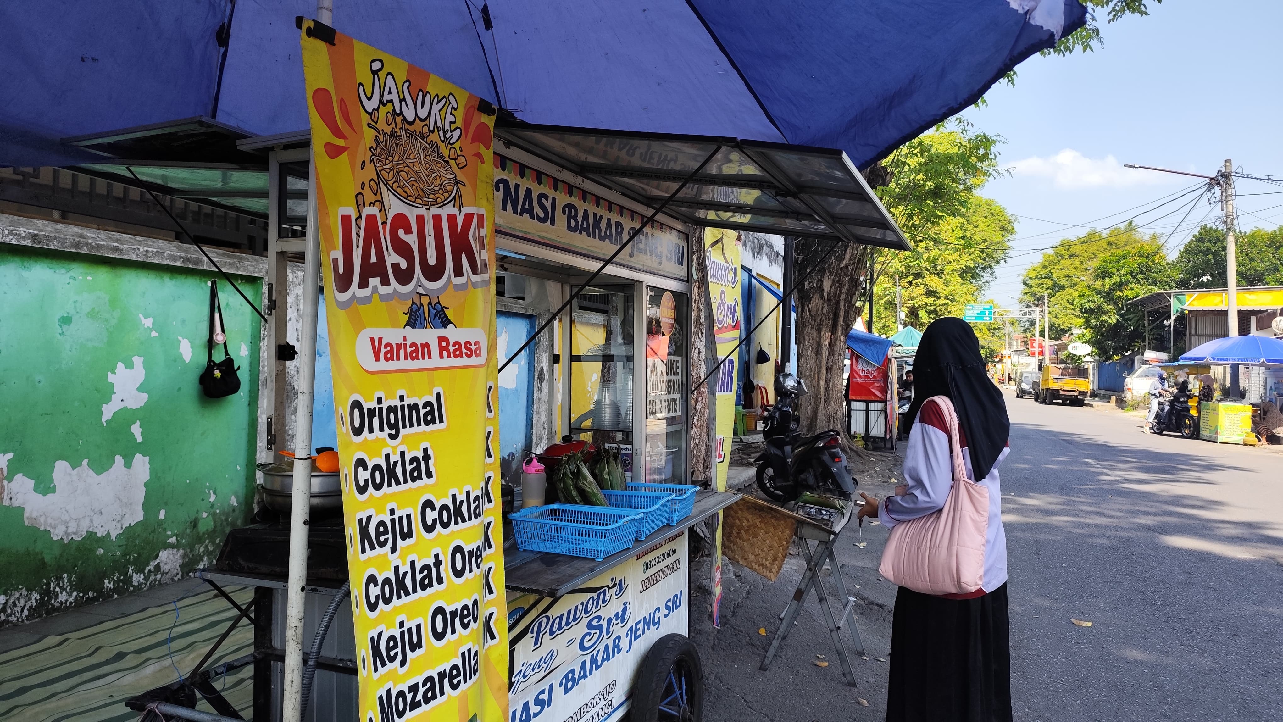 TETAP JUALAN:  Pedagang UMKM di sirip Alun-alun Lumajang tetap berjualan meskipun proyek rehabilitasi tetap berlangsung.(ADE APRYANIS/RAME)