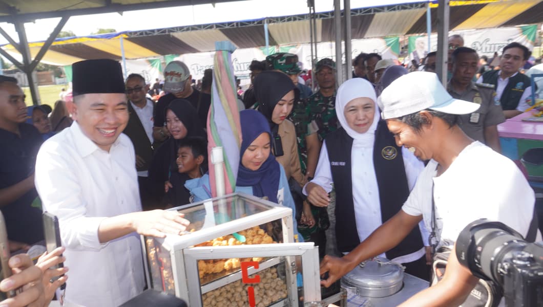 Bupati Fawait (kiri) dan Gubernur Khofifah, saat membuka pasar murah di lapangan Ajung, Jember. Saat itu keduanya membeli dan memborong dagangan cilok (14/9). (Foto: Maulana/Radar Jember)