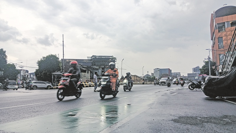 MELAJU: Pengendara langsung tancap gas setelah hujan lebat. BMKG Jember memprediksikan hujan disertai angin kencang dan petir akan berlangsung hingga akhir Oktober.