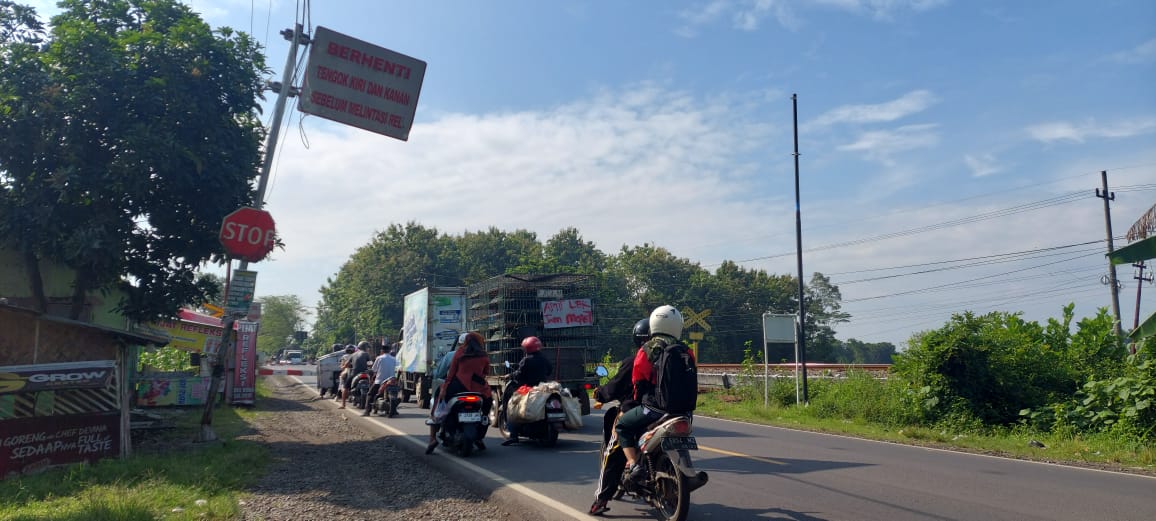 DIBIARKAN NYARIS ROBOH : Rambu himbauan yang ada di barat perlintasan Kereta Api (KA) di Jalan Jaya Negara, Desa Pecoro, Kecamatan Rambipuji yang hanya tinggal menunggu ambruk. (JUMAI/RJ)