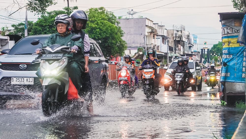 KURANGI KECEPATAN: Sejumlah pengendara melintasi genangan air di Jalan A Yani, Kepatihan setelah terjadi hujan, beberapa waktu lalu.