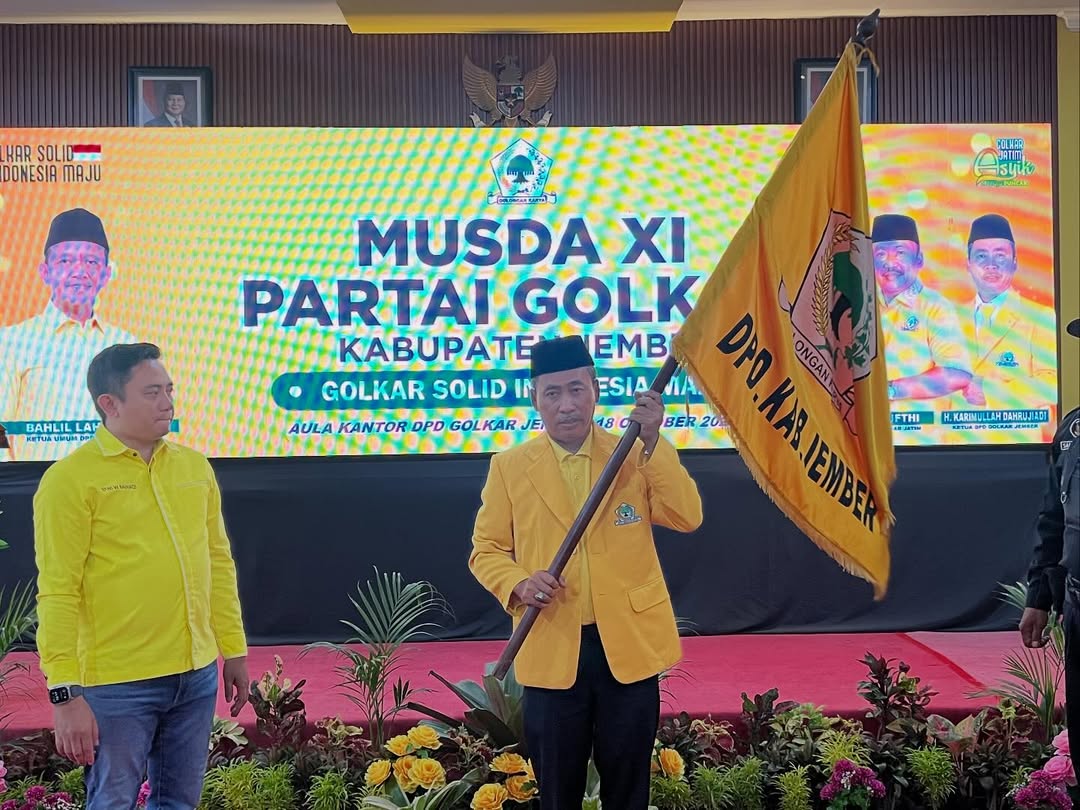 KEPEMIMPINAN BERLANJUT: Karimullah Dahrujiadi memegang pataka partai. Dia kembali terpilih secara aklamasi menjadi Ketua DPD Partai Golkar Jember periode 2025-2030.