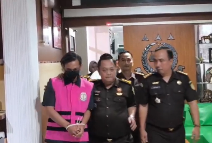 PAKAI ROMPI PINK: Tersangka Dedy, wakil ketua DPRD Jember saat digiring oleh petugas Kejari Jember. (SIDKIN/RJ)