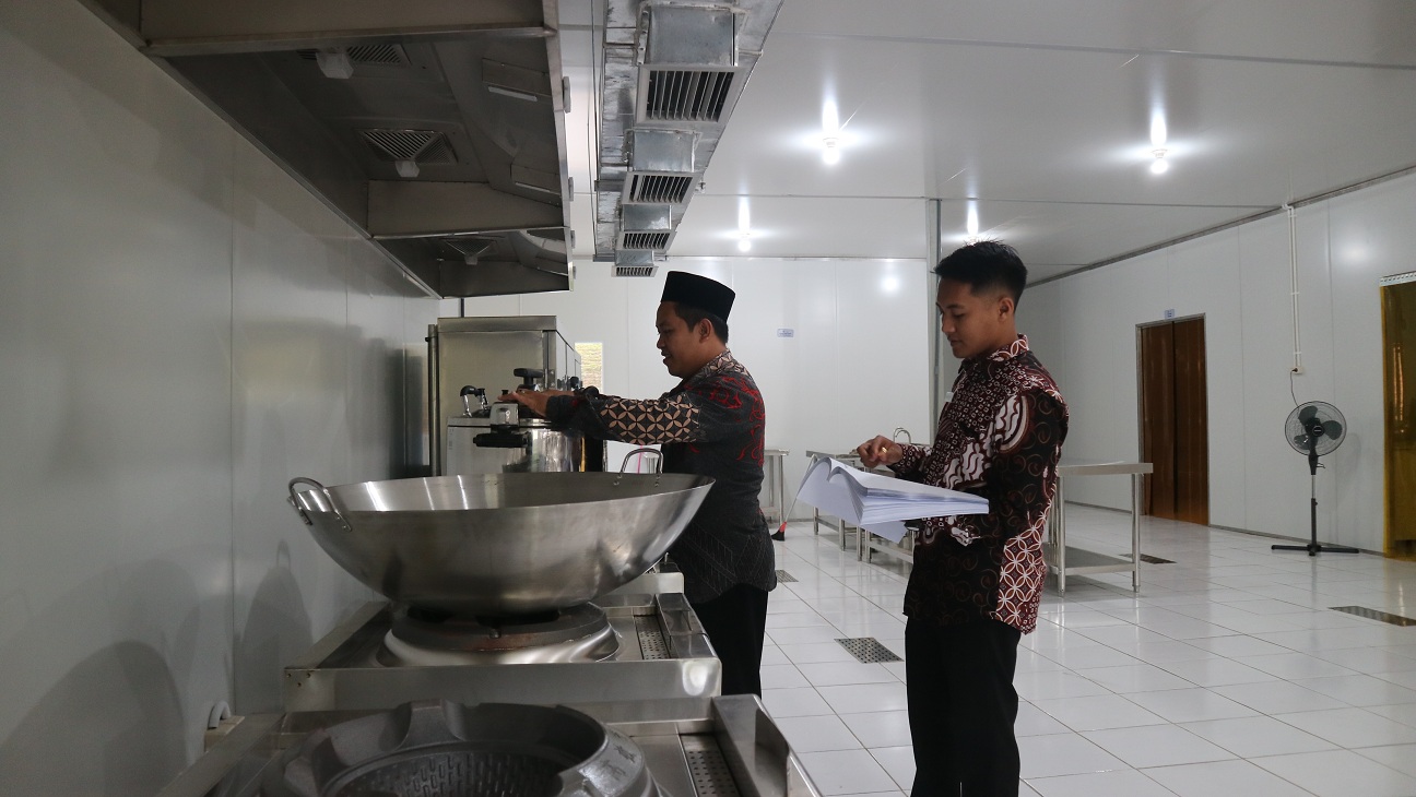 CEK KELENGKAPAN: Kepala Dapur SPPG IBU Pakusari Irdiansyah Firky Prasetyo bersama asisten mengecek peralatan dapur, (22/10) kemarin. Ini untuk memastikan agar dapur MBG siap beroperasi akhir bulan ini