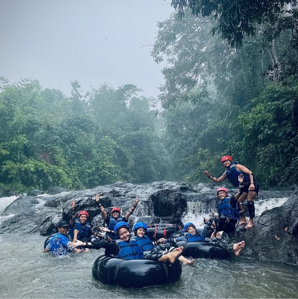 Wisatawan menikmati arus deras Sungai Karangbayat di destinasi Dewakar Tubing, Kecamatan Sumberbaru, Kabupaten Jember.