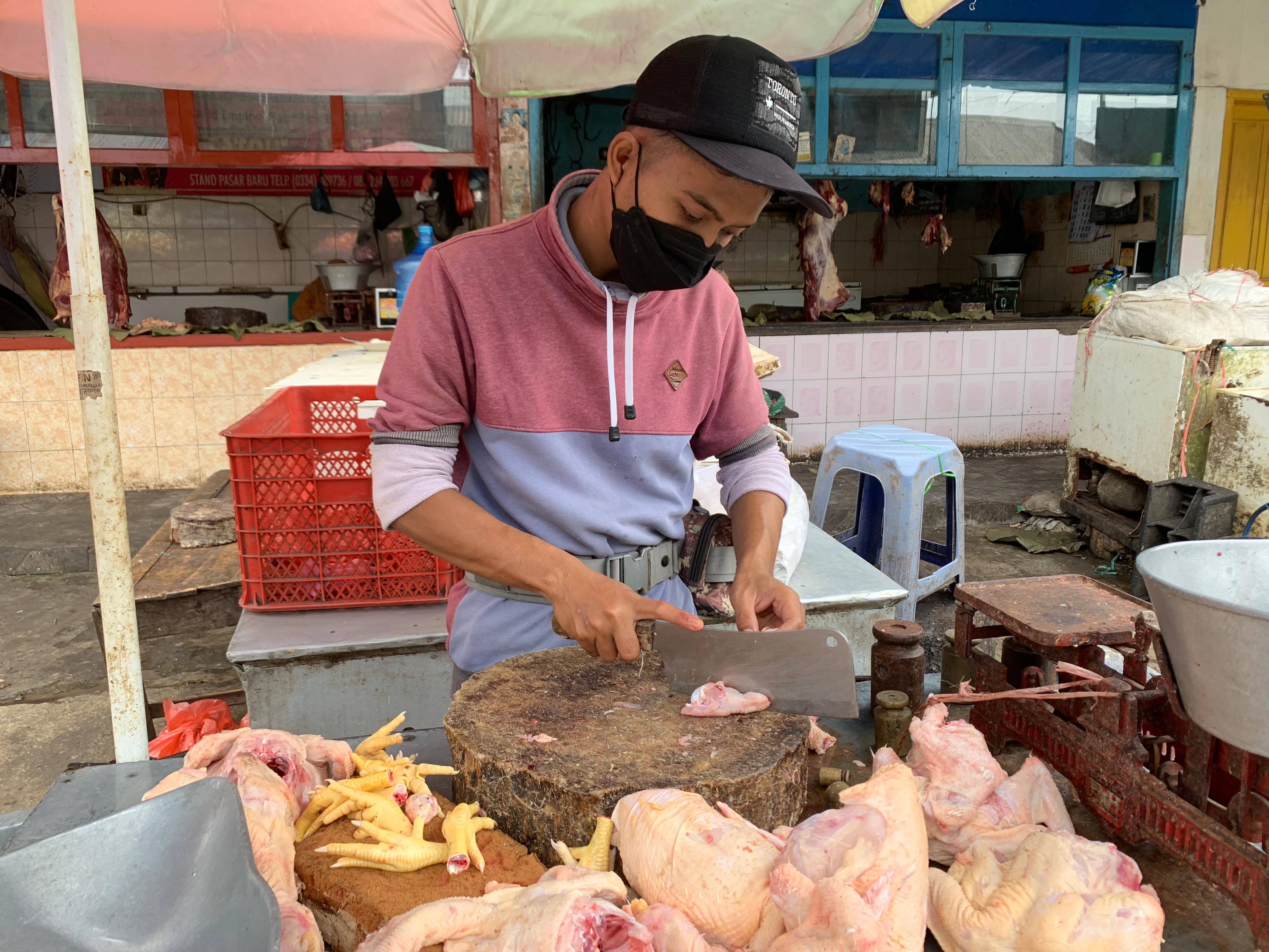 LAYANI: Pedagang ayam di Pasar Baru Lumajang mulai sumringah harga daging ikut menurun, kemarin.(ADE APRYANIS/RAME)