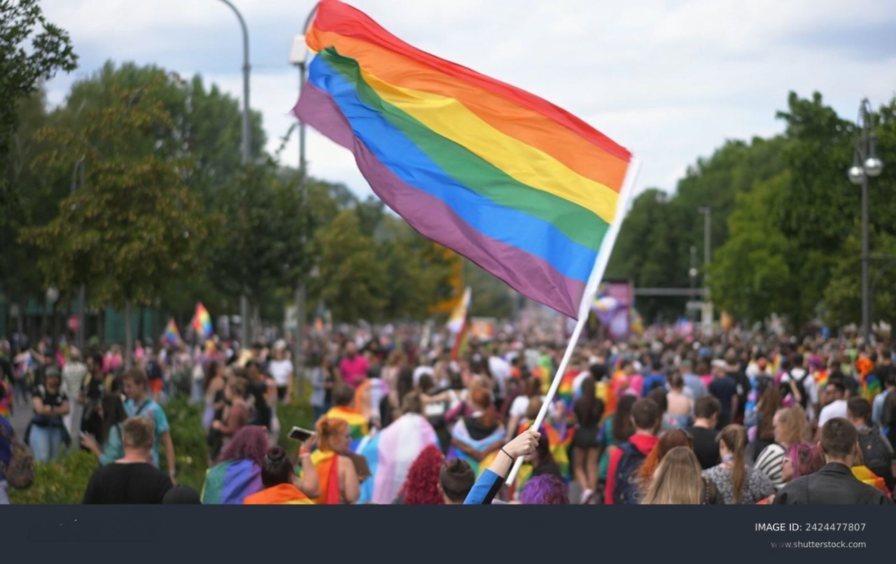 Aksi demonstrans pro LGBT membentangkan bendera pelangi dengan uran raksasa