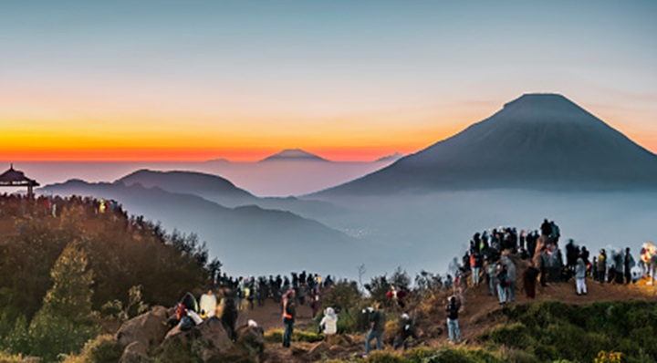 Beautiful first light of sunrise with Sundoro Vulcano silhouette golden hours with soft blue sky background. Taken in Dieng Plateau, Java, Indonesia