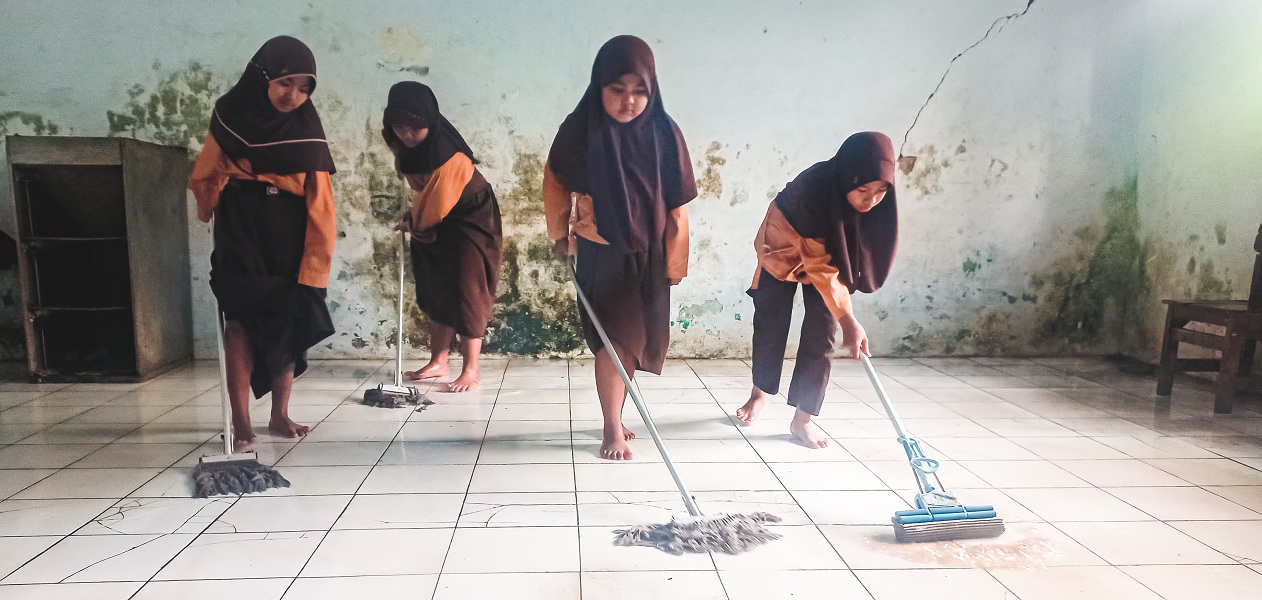 NGEPEL DULU: Sebelum KBM, siswa SDN Curahtakir 03, Kecamatan Tempurejo, terpaksa ngepel ruang kelas karena lantai digenangi air.
