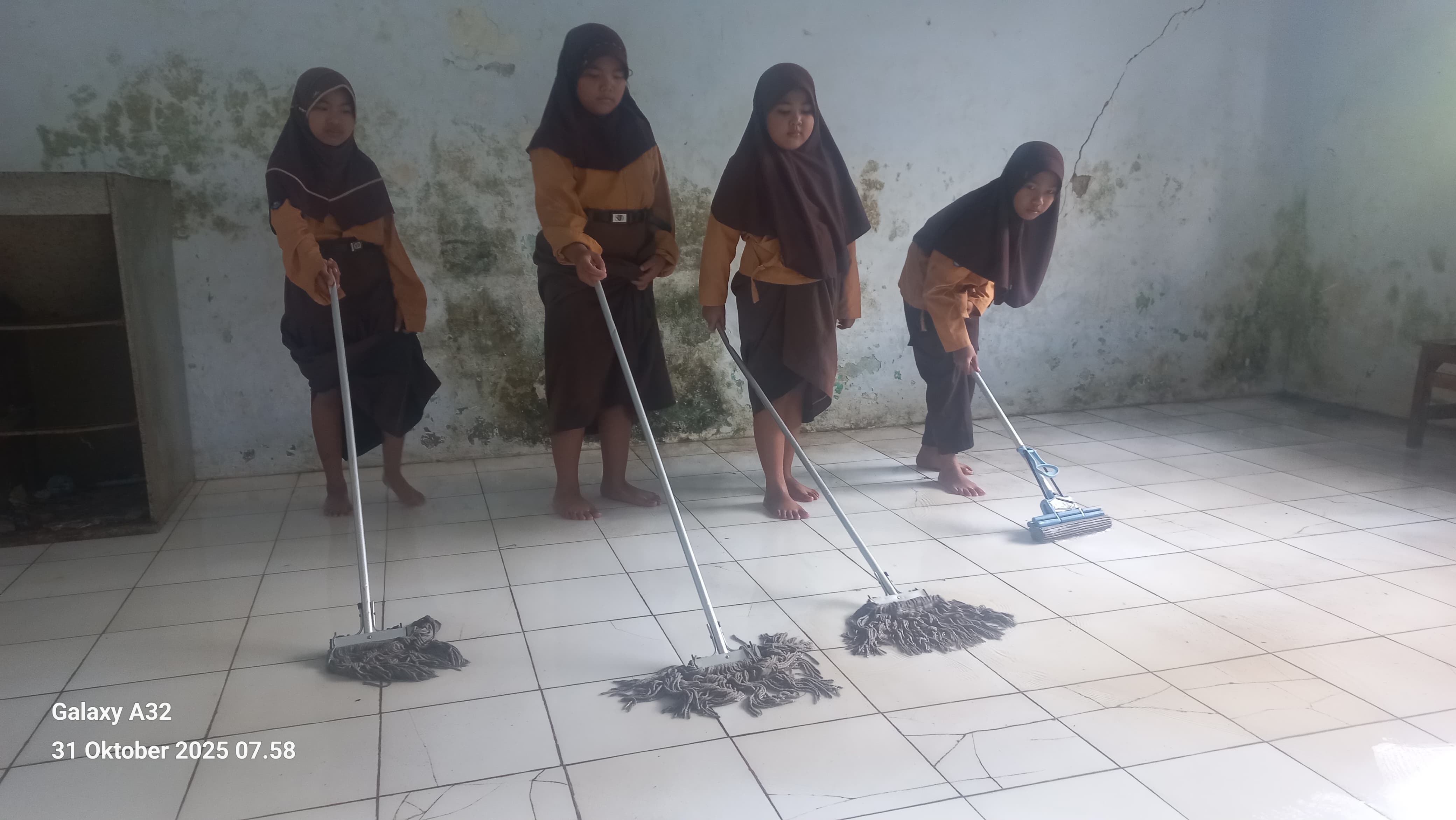 NGEPEL: Siswa SDN Curahtakir 03, Desa Curahtakir, Kecamatan Tempurejo, Jember terpaksa ngepel ruang kelas dulu sebelum mengikuti pembelajaran pada Jumat (31/10/2025)
