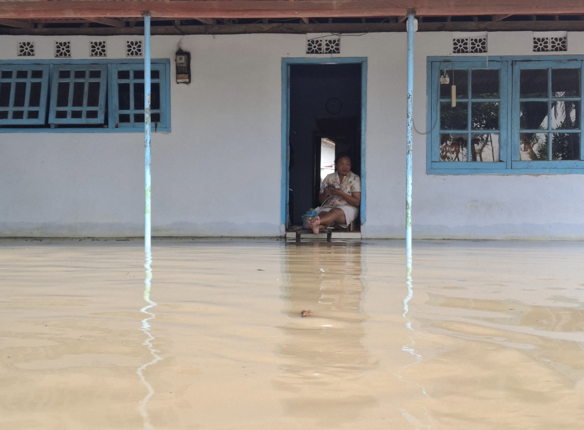 TERDAMPAK: Salah satu warga Desa Rojopolo, Kecamatan Jatiroto saat menunggu air surut di rumahnya, kemarin.(ATIEQSON MAR IQBAL/RAME)