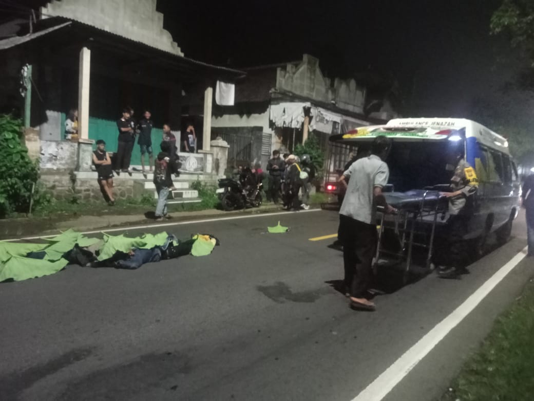 EVAKUASI: Petugas Polsek Mayang dan Puskesmas Mayang mengevakuasi korban tabrak lari di Jalan nasional Jember &ndash; Banyuwangi, Kecamatan Mayang.