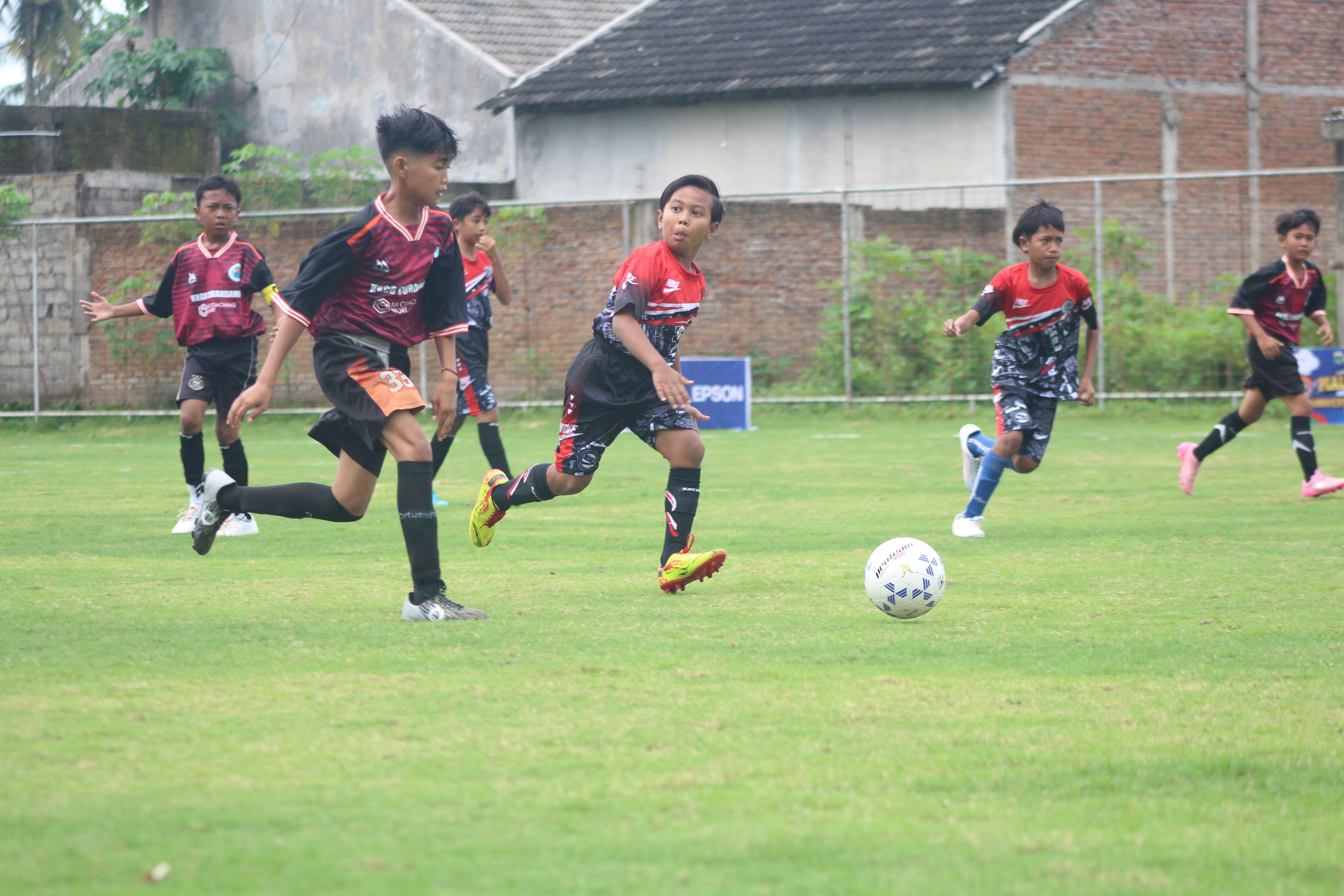 SENGIT: Salah satu pemain mini soccer di Bondowoso berjuang mempertahankan bola di lapangan Arseko, kemarin.
