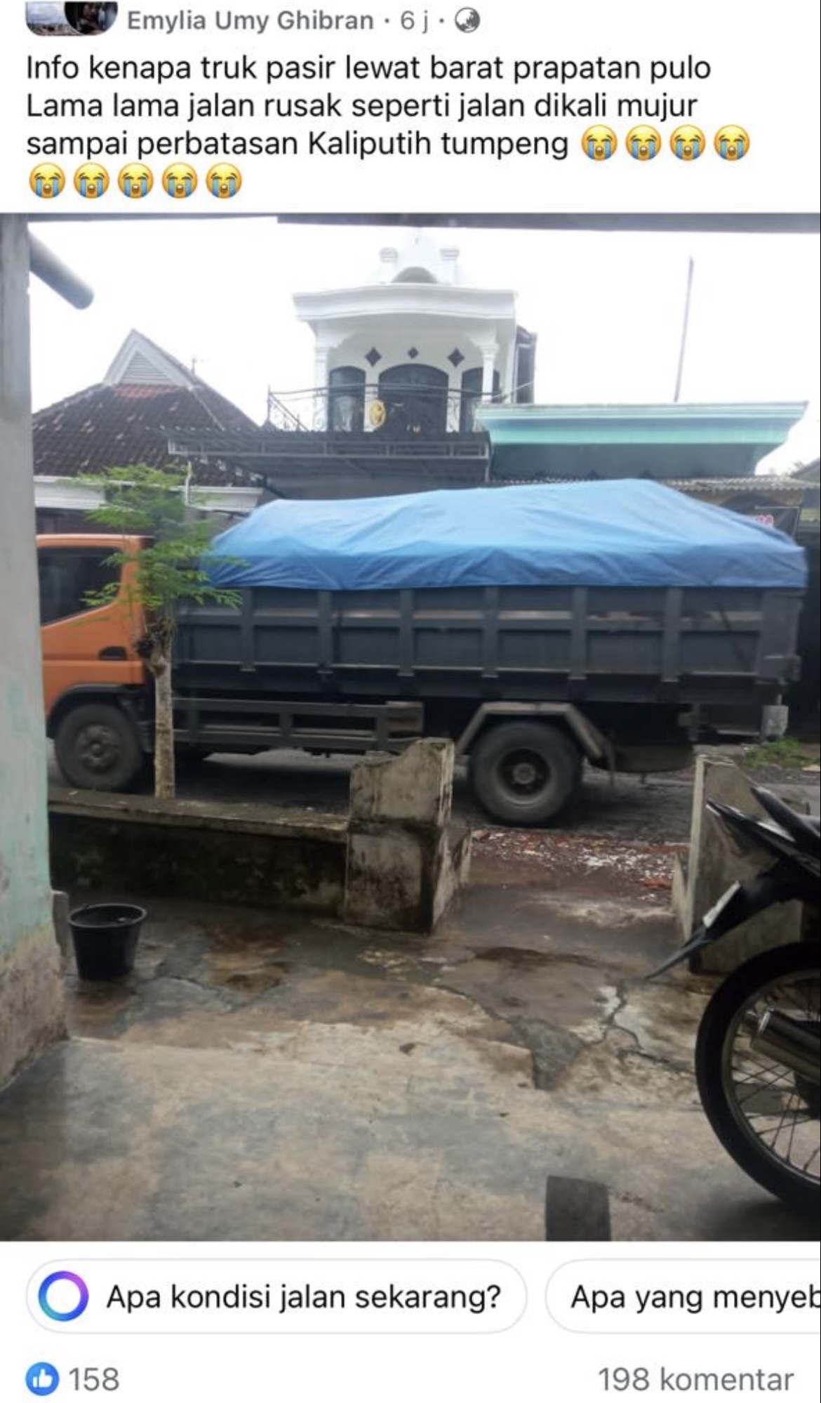 Tangkap layar kondisi truk muatan pasir melintas di jalan kecil.