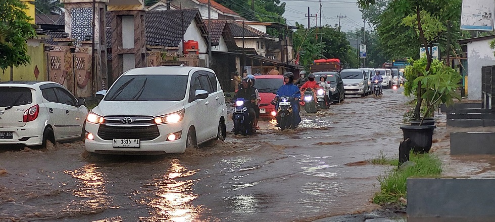 PERLU PENANGANAN: Jalan nasional jurusan Jember - Surabaya Dusun Krajan, Desa Langkap, Kecamatan Bangsalsari banjir karena air di selokan meluap.