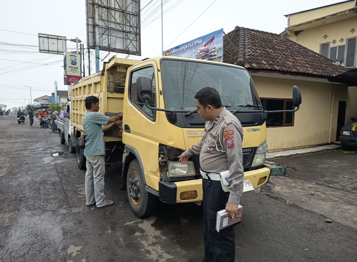 TUNJUKKAN: Petugas kepolisian saat mengamankan dump truk yang terlibat laka lantas, kemarin.(SATLANTAS FOR RAME)