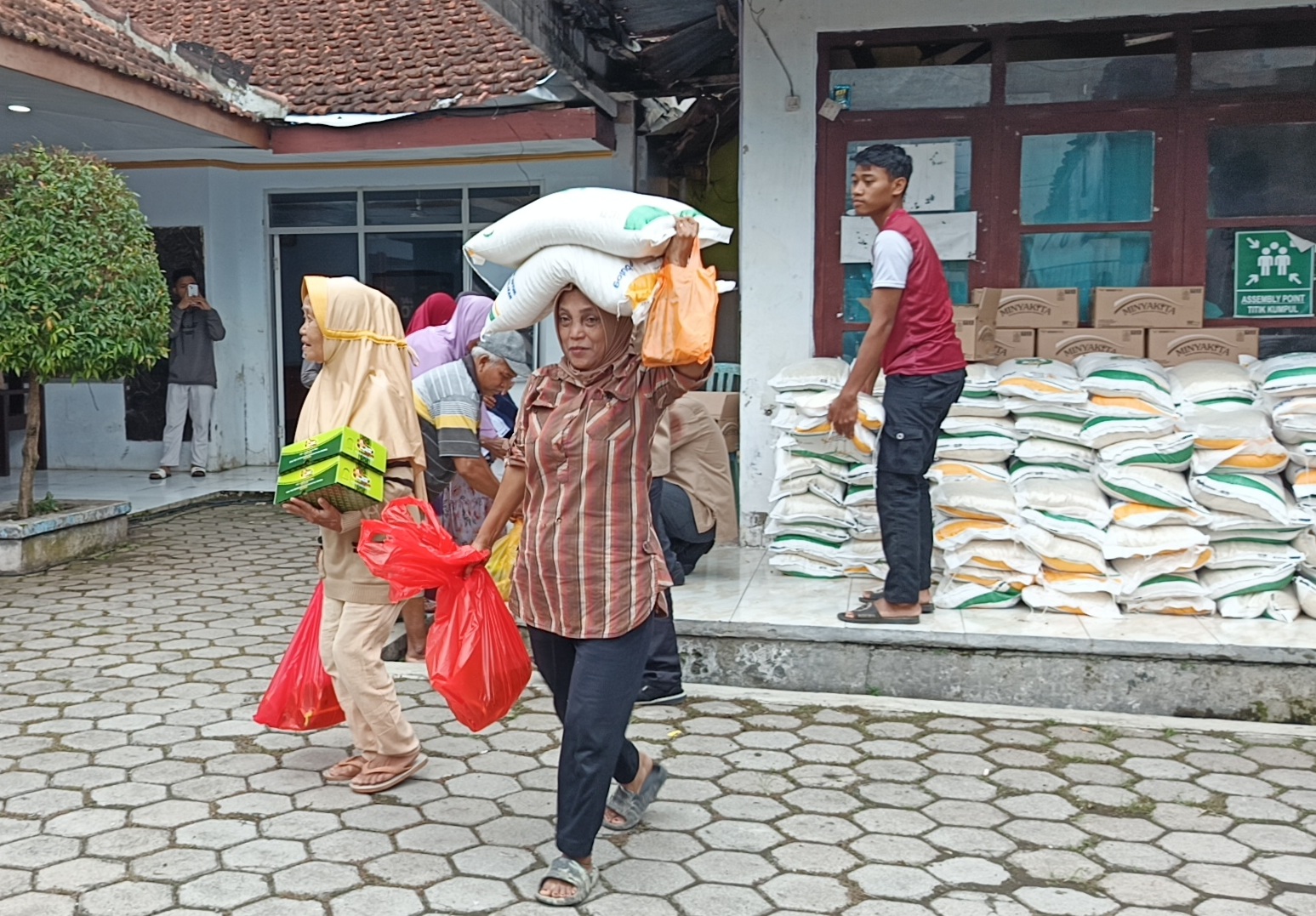 KUCURAN PUSAT: Sejumlah warga menerima bantuan pangan di Kelurahan Wirolegi, Kecamatan Sumbersari, Jember, Jumat (14/11).