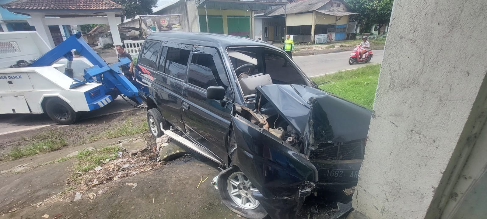 RUSAK PARAH: Mobil Isuzu Panther DK 1682 AR yang disopiri Nur Muhammad Amanu, 31 mengalami rusak parah setelah menabrak tembok toko bangunan di Jalan Raya Desa Kertonegoro, Kecamatan Jenggawah
