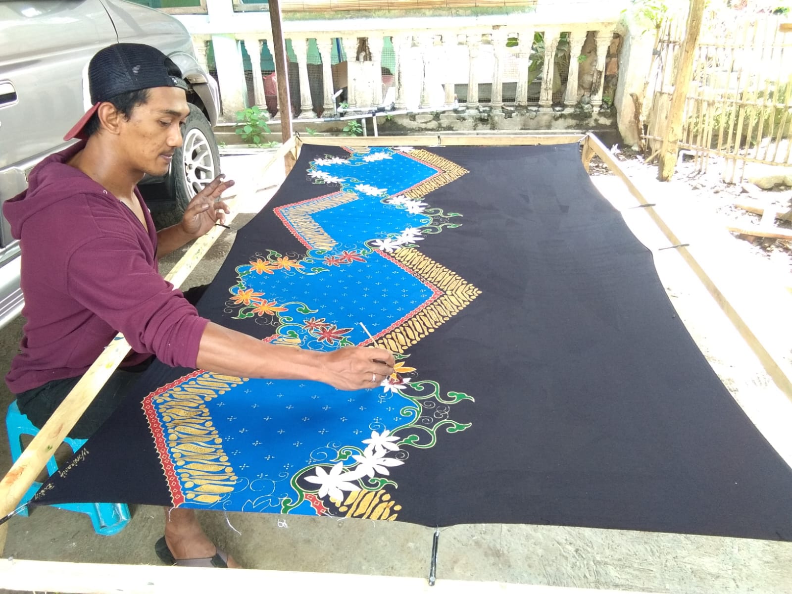 TELATEN: Salah seorang pembatik yang sedang berkonsentrasi memberikan sentuhan indah di atas kain batik.