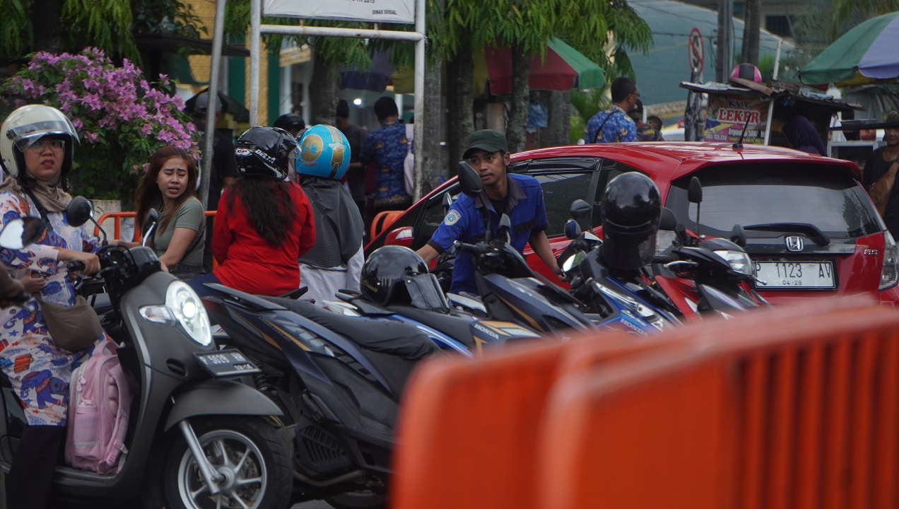 PARKIR BERLANGGANAN: Petugas parkir beroperasi di sekitar Alun-Alun Jember. Fraksi PPP meminta skema parkir berlangganan diterapkan lagi dan bupati memberi sinyal hijau.
