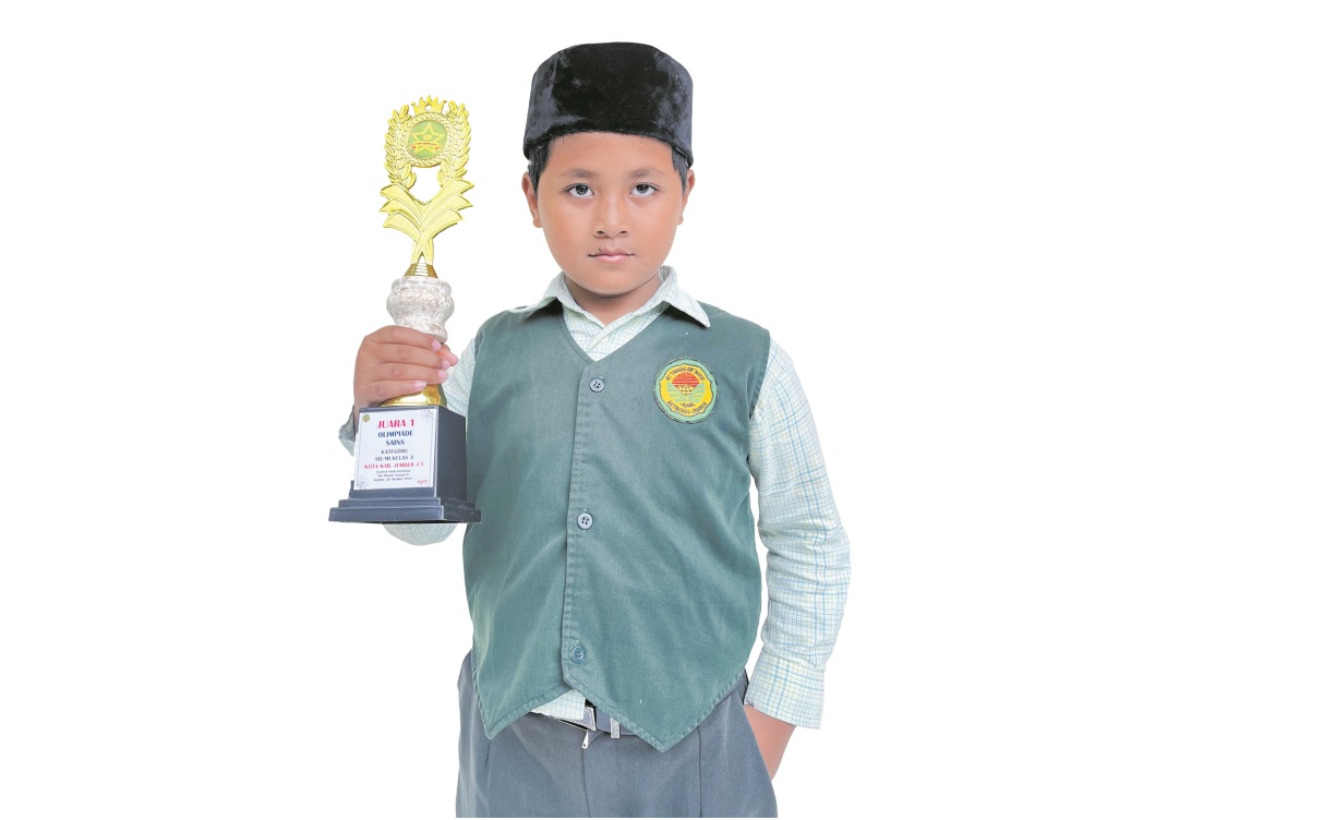 ANGKAT TROFI: Muhammad Galih Bintang Pradana, siswa kelas 3 MI Unggulan Nuris Jember, sabet Juara 1 Sains se-Jawa Timur.