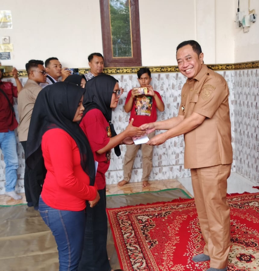 SUMRINGAH: Salah seorang buruh tembakau di Bondowoso menerima bantuan DBHCHT, dari Bupati Bondowoso.