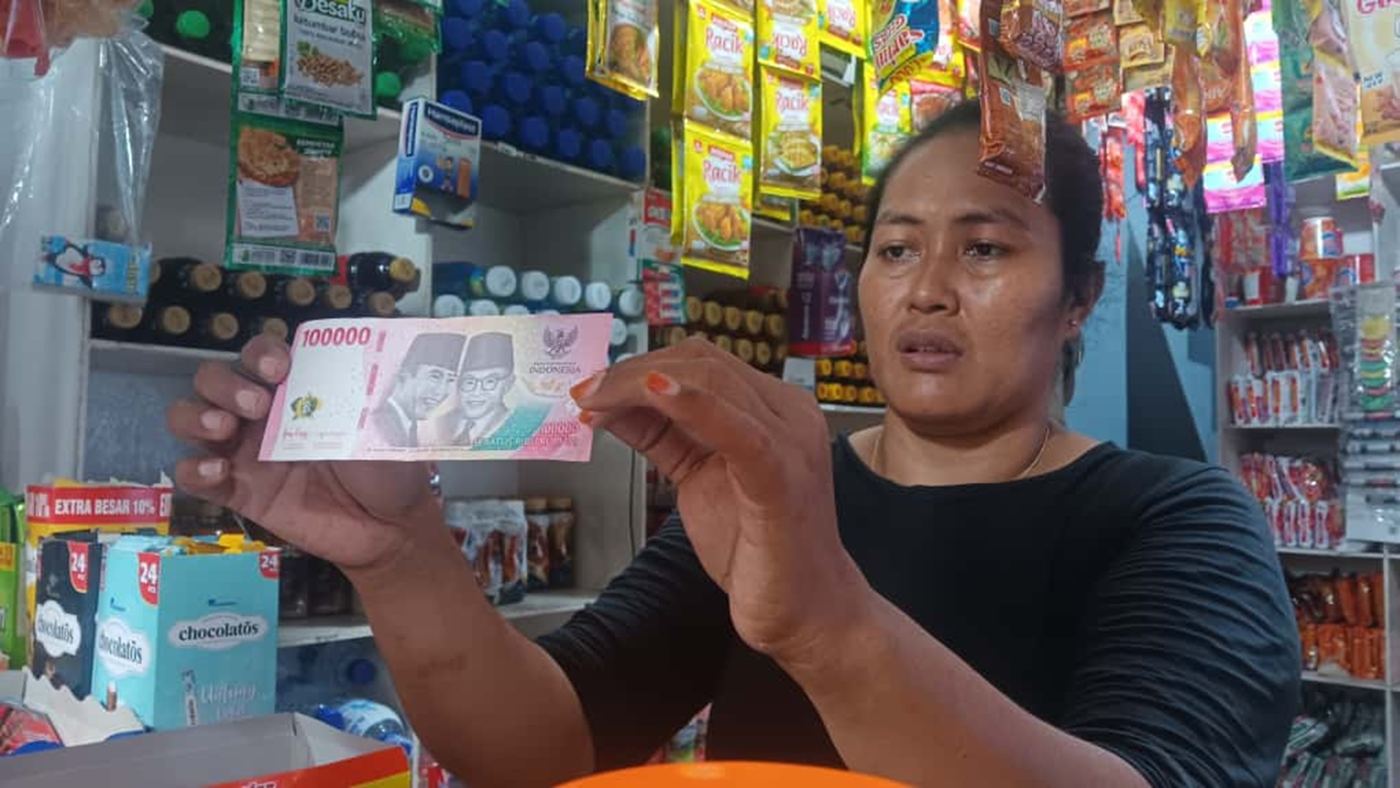 CEK KEASLIAN: Penjaga toko Madura di sekitar Kelurahan Kepatihan, Kecamatan Kaliwates, Jember, menerawang uang pecahan seratus ribu rupiah.