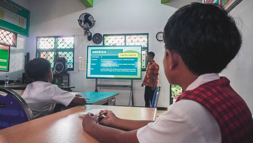 SEMAKIN MAJU: Siswa menyimak penjelasan guru SDN Jember Lor 04 yang mengajar dengan memanfaatkan smartboard bantuan dari Presiden Prabowo.