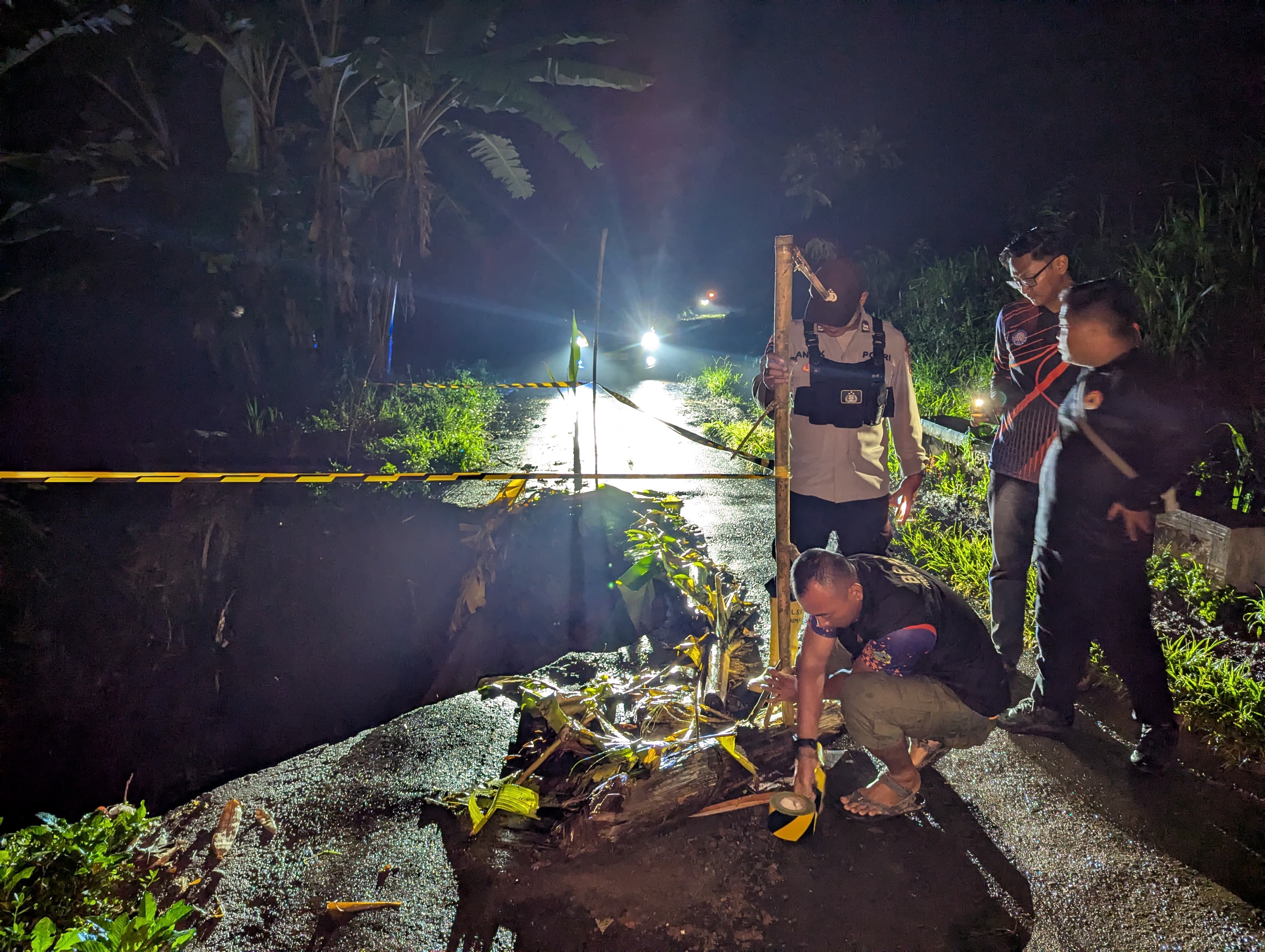LANGSUNG TINJAU LOKASI: Petugas BPBD saat mengecek kondisi longsor akibat cuaca ekstrem, Selasa (26/11) malam.