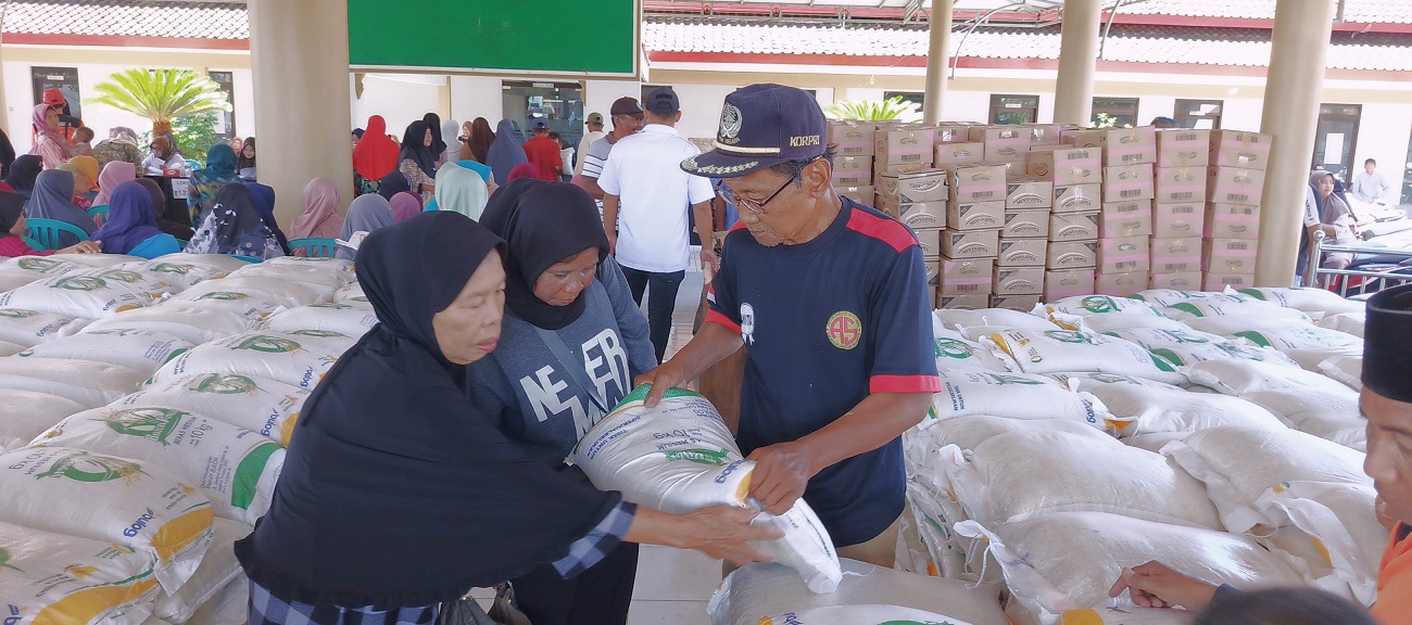TERIMA HAK: Salah satu penyaluran bantuan pangan berupa beras dan minyak yang dilangsungkan di Balai Desa Sidomekar Kecamatan Semboro, kemarin (3/12).