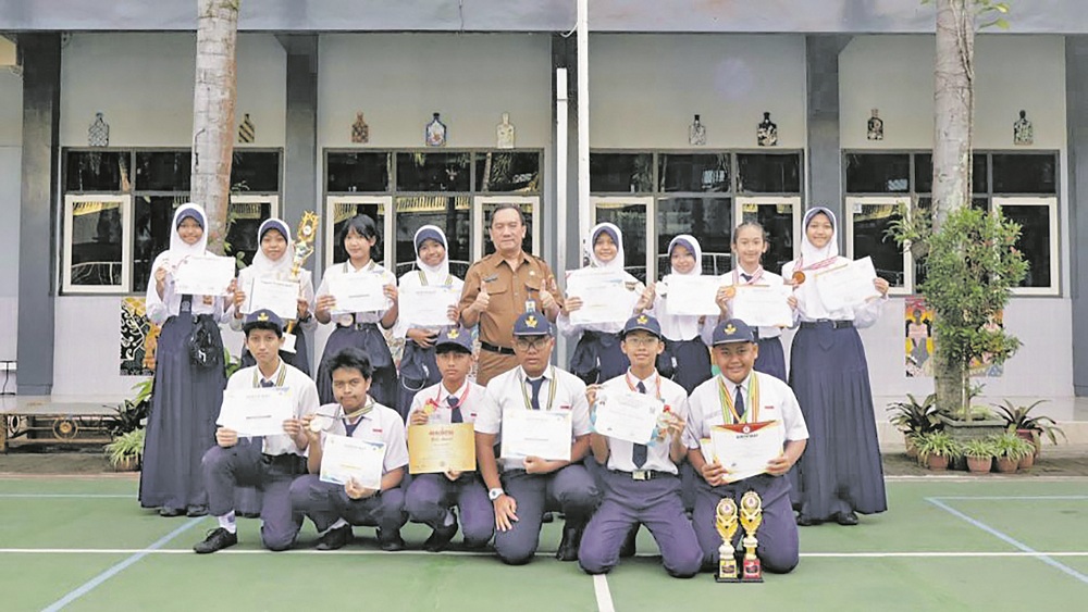 UNJUK GIGI: Para siswa SMPN 2 Jember yang mendapatkan berbagai prestasi berfoto bersama Kepala SMPN 2 Jember.