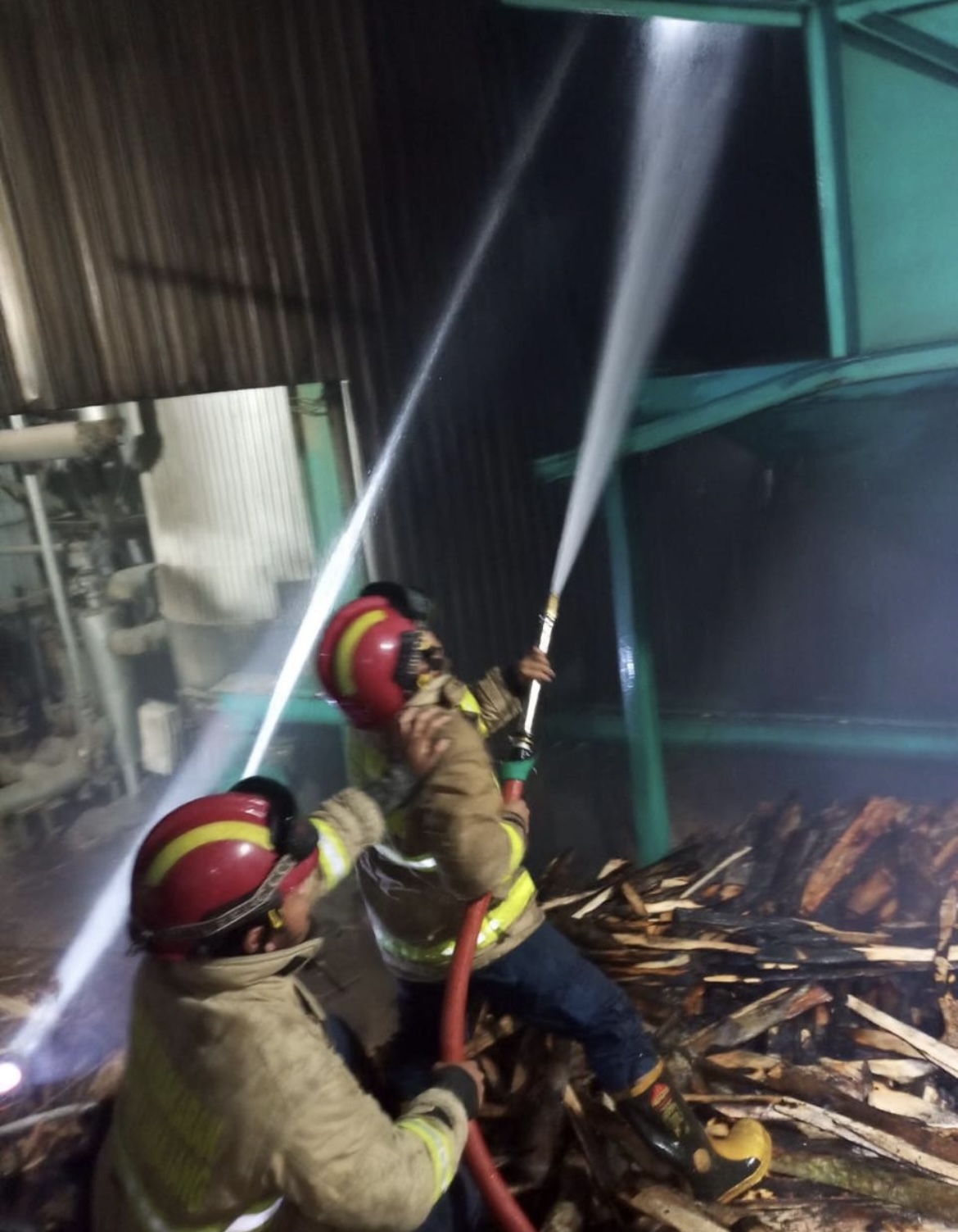 PADAMAKAN: Petugas pemadam kebakaran Lumajang saat berusaha memadamkan api yang melahap gudang kayu, kemarin malam.(DAMKAR FOR RAME)