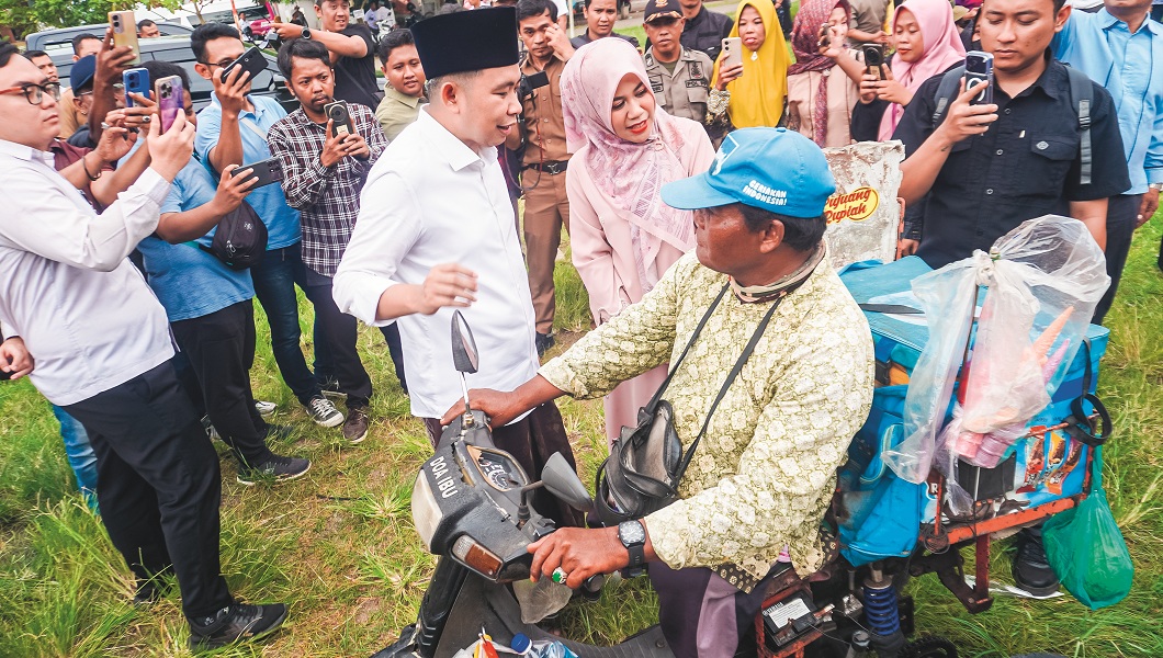 HANGAT: Jailani, penjual es krim, disapa Bupati Fawait yang kemudian memborong dagangannya, dalam acara Guse Menyapa, Apel Sholawat Kebangsaan, di RTH Kecamatan Balung, Senin (8/12).