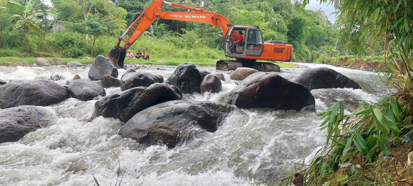 NORMALISASI: Alat berat jenis excavator Dinas PU BMSDA Jember melakukan normalisasi Sungai Petung, di Desa Pakis, Kecamatan Bangsalsari, Jumat (12/12) siang.