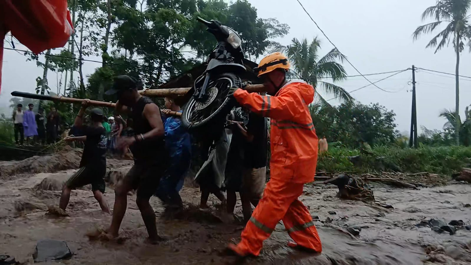 BERSAMA-SAMA: Warga dan BPBD bersama-sama menggotong sepeda motor diselamatkan dari banjir. (ILHAM/RJ)