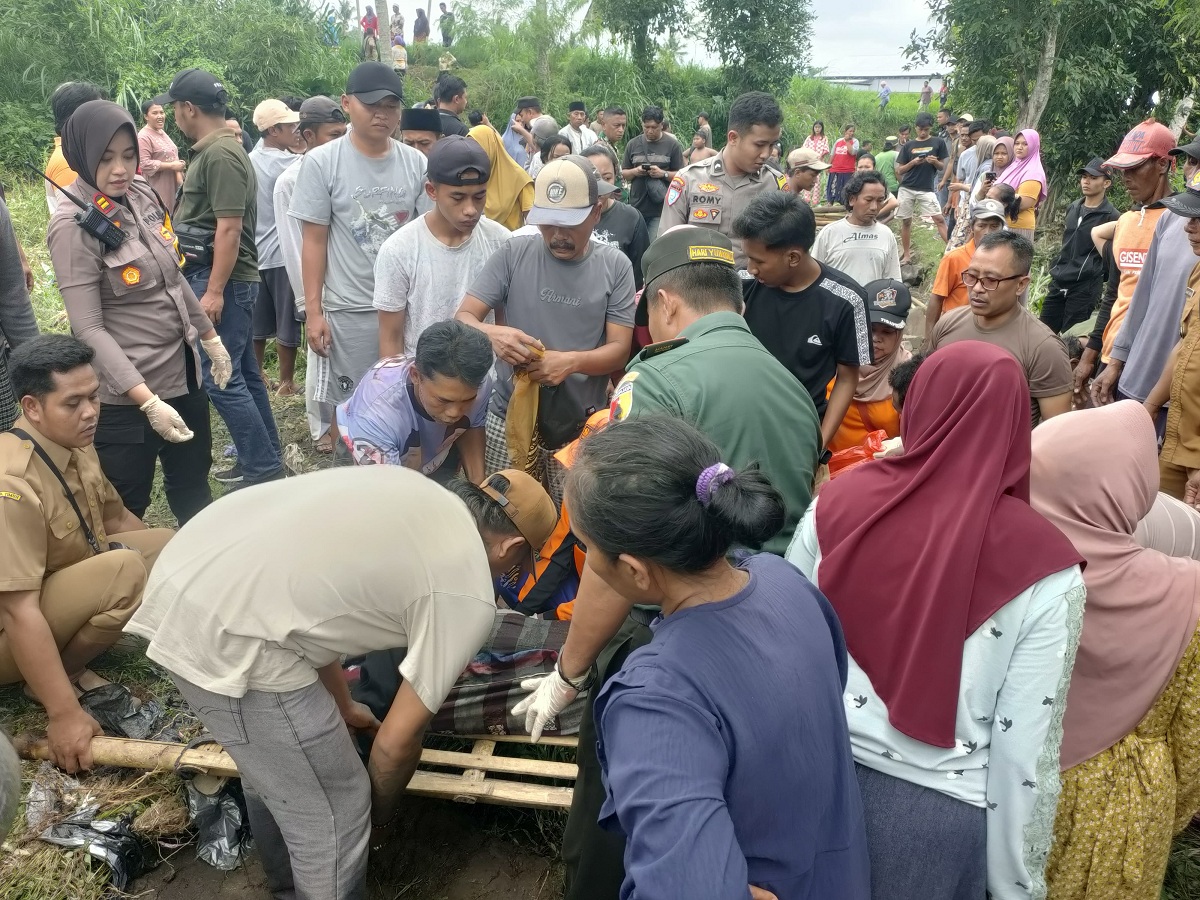 EVAKUASI: Kapolsek Kalisat Iptu Ika Mufid bersama anggotanya dan Babinsa serta perangkat desa setempat melakukan evakuasi korban yang ditemukan tewas di pinggir sungai, Selasa (16/12).