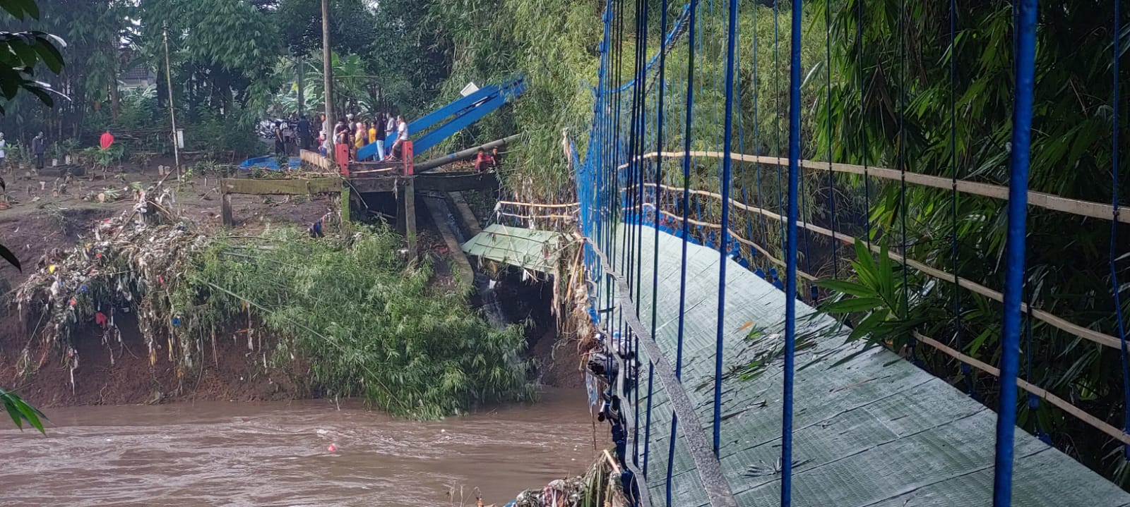 PUTUS: Jembatan gantung yang menghubungkan Dusun Darungan Selatan dengan Darusan Utara, Desa Jubung, Kecamatan Sukorambi, Jember putus setelah diterjang banjir pada Senin (15/12/2025) malam