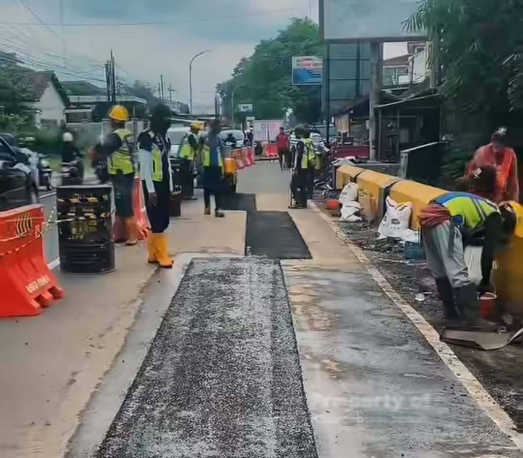BEKERJA: Sejumlah petugas teknis PU Bina Marga Provinsi Jatim saat memperbaiki permukaan retakan jembatan.