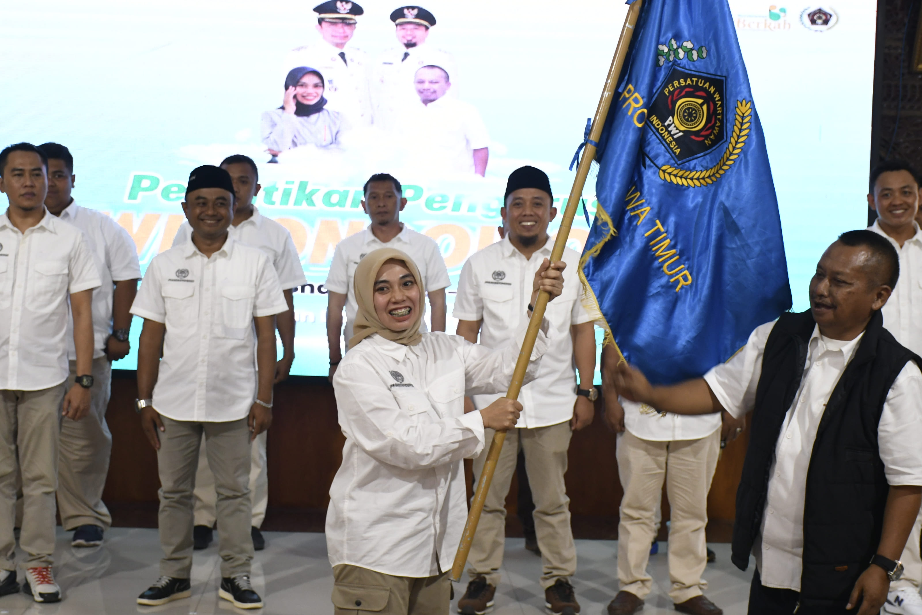 Ketua PWI Jatim, Lutfil Hakim (kanan) menyerahkan bendera PWI kepada Ketua PWI Bondowoso, Sinca Ari Pangestu (kiri).