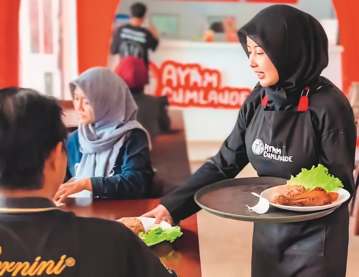 RAMAH MELAYANI: Karyawan Ayam Cumlaude melayani pengunjung yang makan di outlet. Ayam Cumlaude menjadi salah satu primadona semua kalangan dengan cita rasa nasi rempah yang khas di Jember.