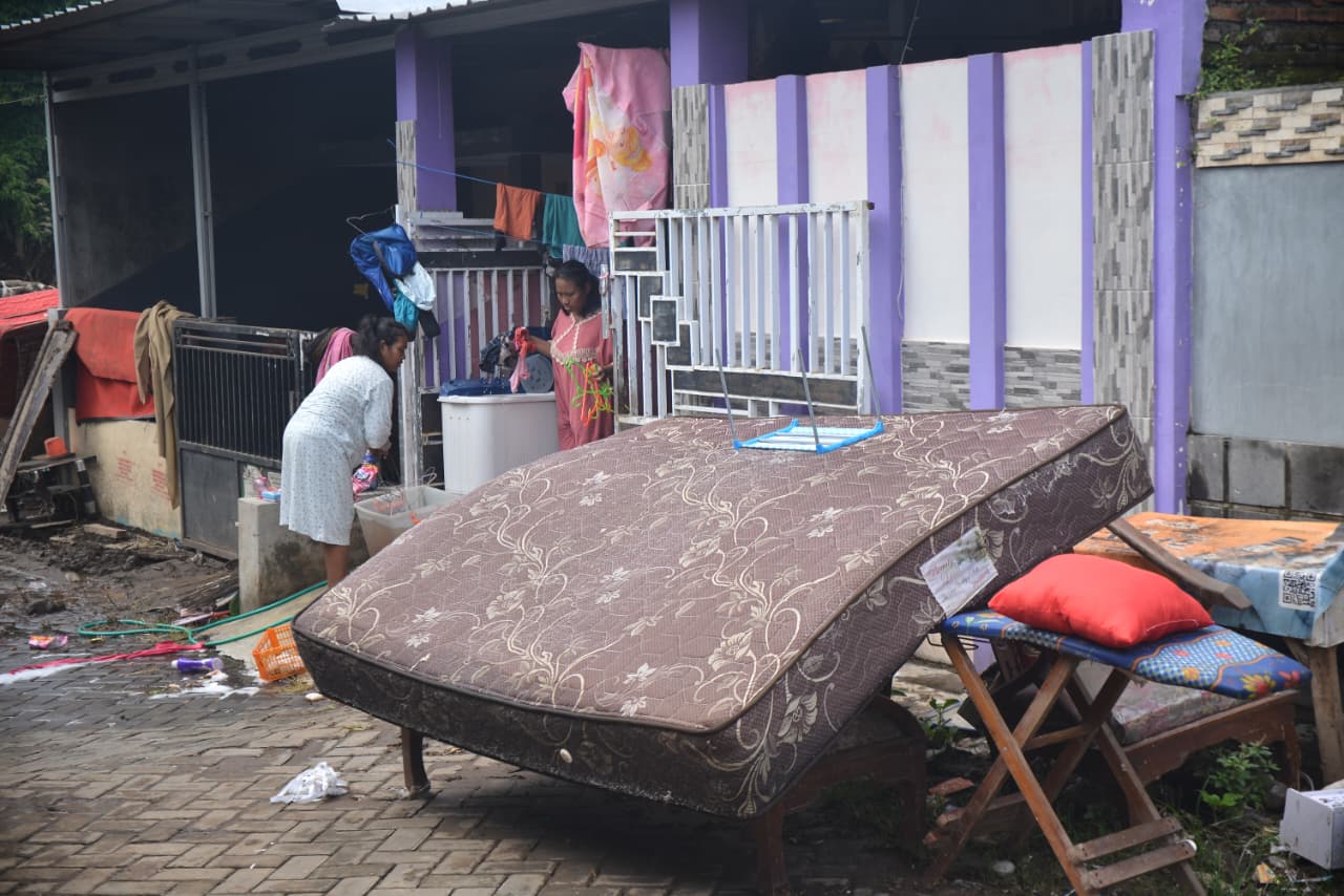 BERSIH-BERSIH: Warga setempat, Iluk Prawati mulai membersihkan perabotan, baju dan kasur yang terendam banjir.