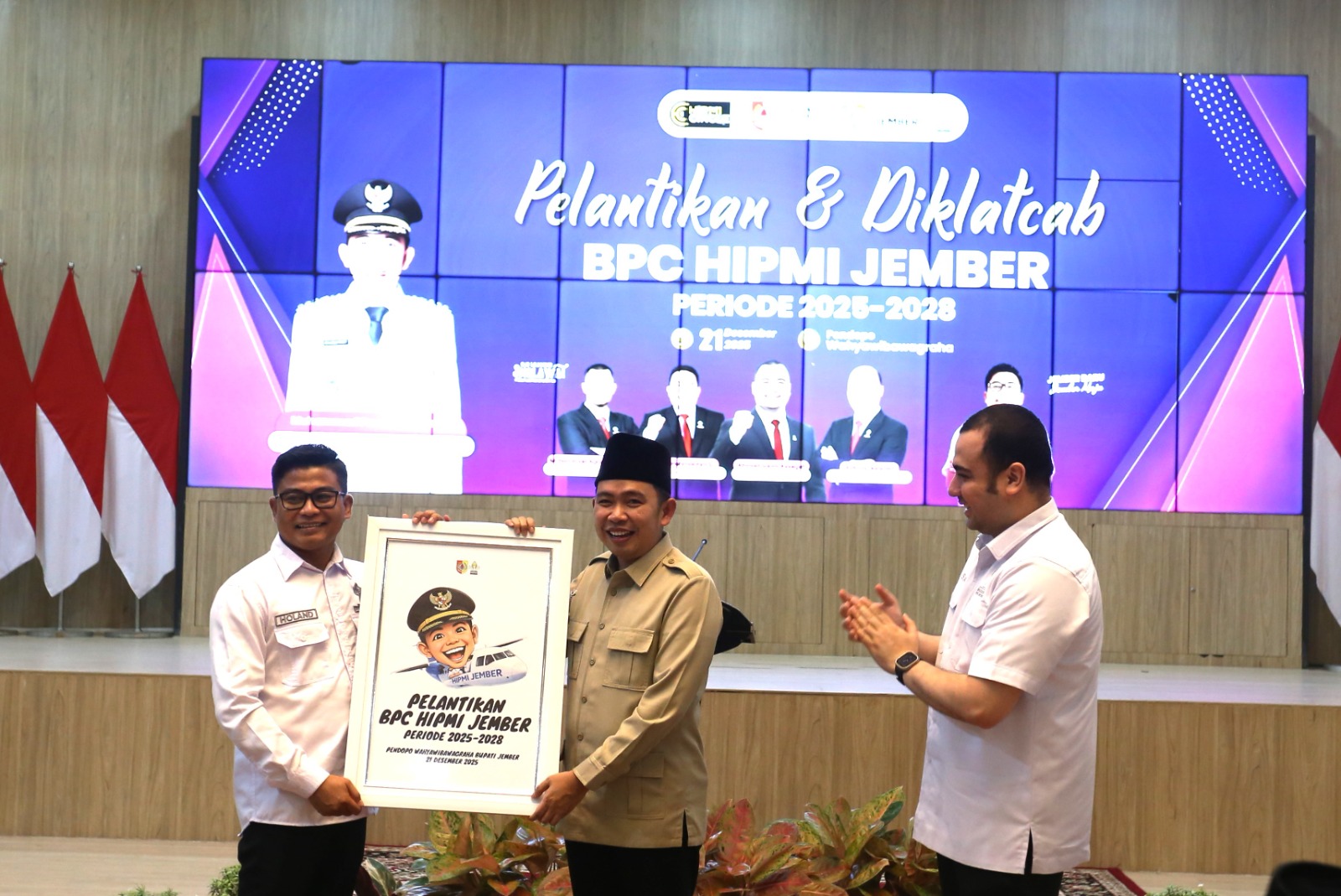 DISERAHKAN: Ketua BPC HIPMI Jember Holand Sanjaya menyerahkan cendera mata kepada Bupati Jember Muhammad Fawait seusai pelantikan pengurus HIPMI Jember 2025-2028 di Pendapa Wahyawibawagraha, Minggu (2