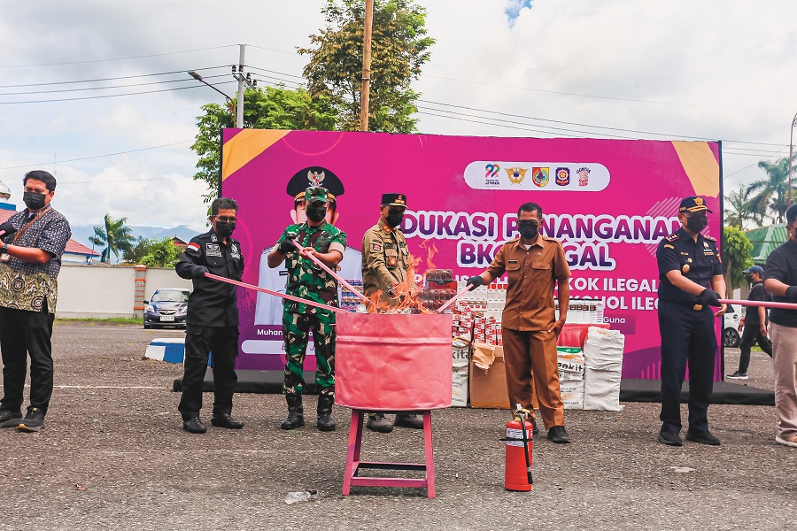 Kepala Satpol PP Jember Bambang Rudianto (tengah) bersama Kepala Bea Cukai Jember Muhammad Syahirul Alim dan sejumlah pejabat membakar rokok dan minuman beralkohol ilegal di Balai Serbaguna.