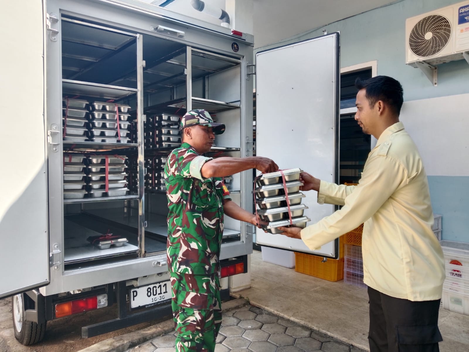 DIKAWAL KETAT: Salah satu anggota TNI di Bondowoso memantau langsung proses penyaluran MBG kepada siswa di sekolah.