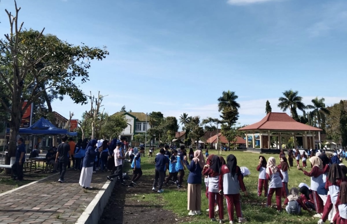 KOMPAK: Ratusan pelajar dan guru SMPN 2 Tamanan memungut sampah yang berceceran di area Alun-alun setempat, kemarin.(ILHAM WAHYUDI/RADAR IJEN)